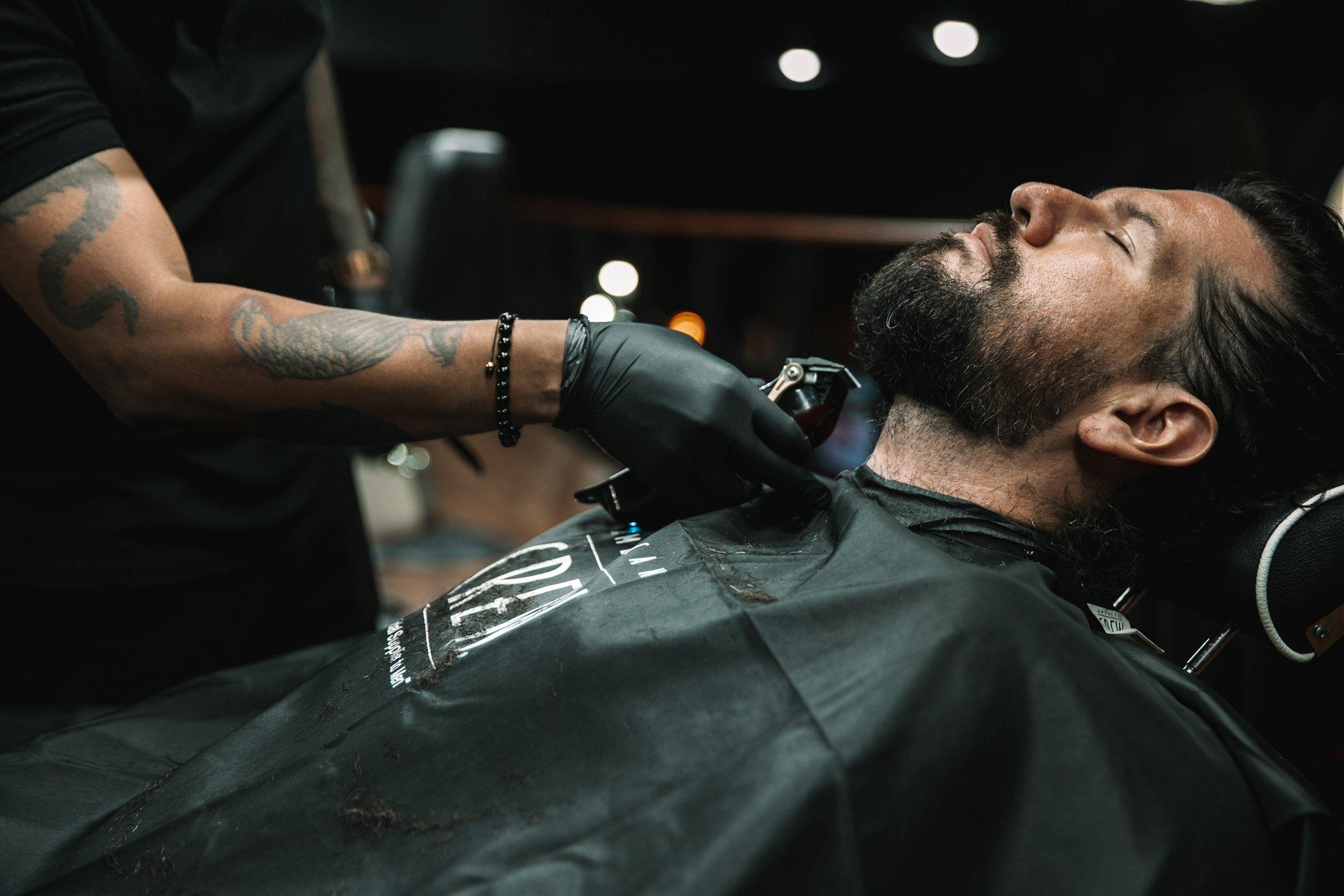 Barbero atendiendo a un cliente en su barbería